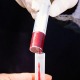 Blutprobe wird von Spritze in Röhrchen umgefüllt.